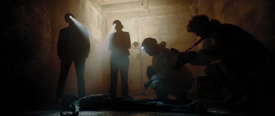 A group of forensic investigators wearing headlamps investigate a ritualistic crime scene in "Charismata"