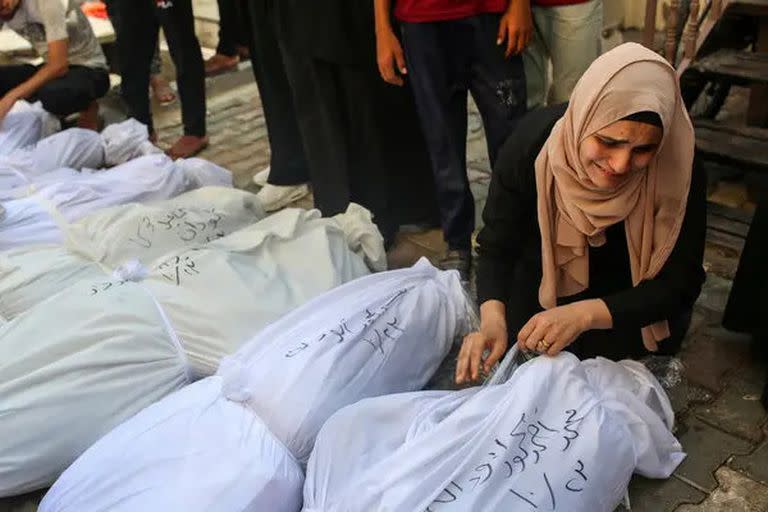 Una mujer llora a sus hermanos y hermanas muertos durante los ataques aéreos israelíes en Deir al-Balah, en el centro de Gaza