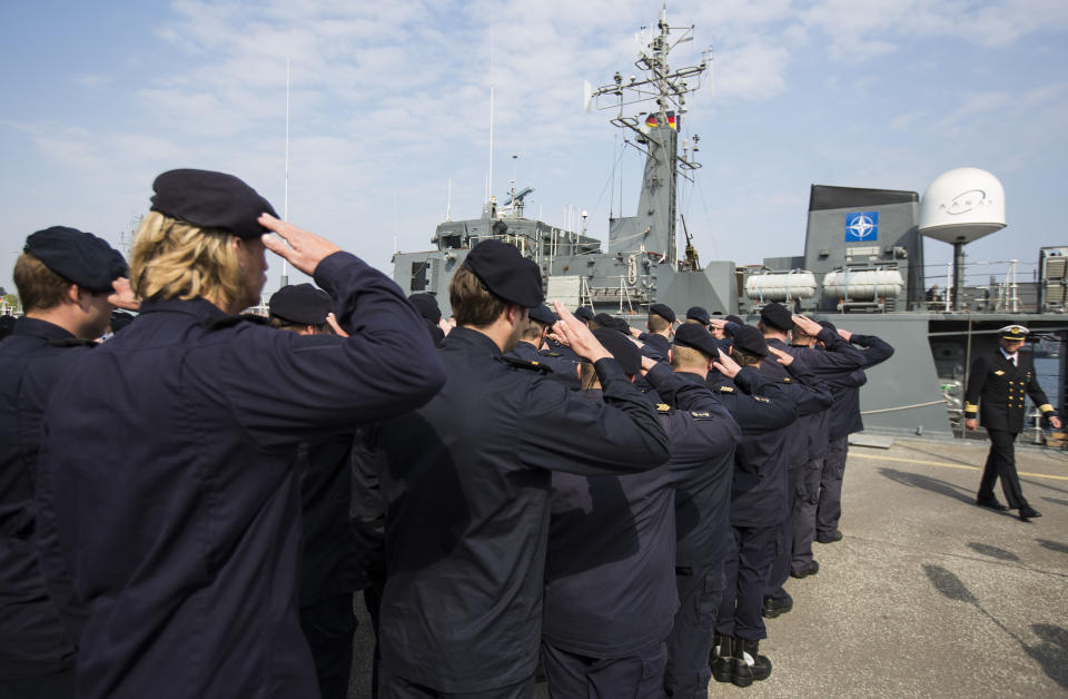 Crew members of Norwegian minesweeper Otra salute after a briefing of NATO Allied Maritime Command Deputy Chief of Staff for Operations, Commodore Arian Minderhoud, right, of the Royal Netherlands Navy before setting sail together in a convoy of five ships of Norway, Belgium, the Netherlands and Estonia from Kiel, Germany, Tuesday, April 22, 2014. The warships are part of the standing NATO Mine Counter-Measures Group ONE, one of NATO’s four standing Maritime Forces, deploying to the Baltic Sea to enhance maritime security and readiness in the region. The maritime Group was reactivated by a North Atlantic Council decision to enhance collective defense and assurance measures in response to the crisis in Ukraine. (AP Photo/Gero Breloer)