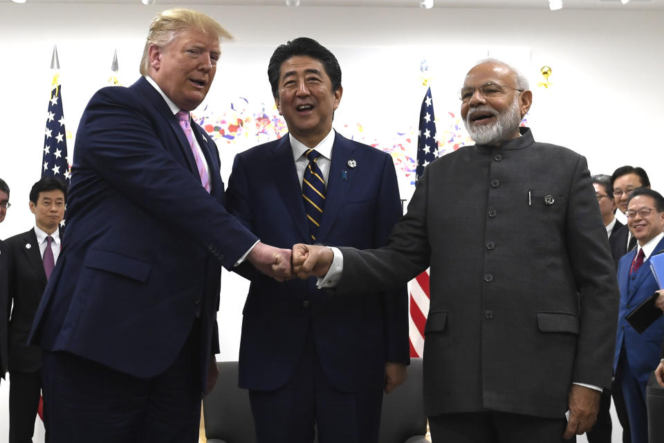 FILE- In this June 28, 2019 file photo, President Donald Trump, Japanese Prime Minister Shinzo Abe and Indian Prime Minister Narendra Modi share a fist bump during their meeting on the sidelines of the G-20 summit in Osaka, Japan. These days, Modi is seen around the world as a key Asian leader. He’s known for welcoming foreign heads of state with bear hugs. He has addressed a joint session of the U.S. Congress. (AP Photo/Susan Walsh, File)