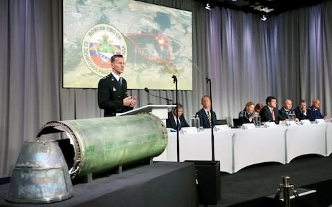 Dutch police investigator Wilbert Paulissen next to the engine casing and thrust nozzile of the missile that brought down MH17 - Credit: FRANCOIS LENOIR /Reuters