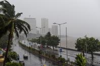 Motorists drive on a road near the Marine Drive under heavy rain in Mumbai on June 3, 2020. (Photo by PUNIT PARANJPE/AFP via Getty Images)