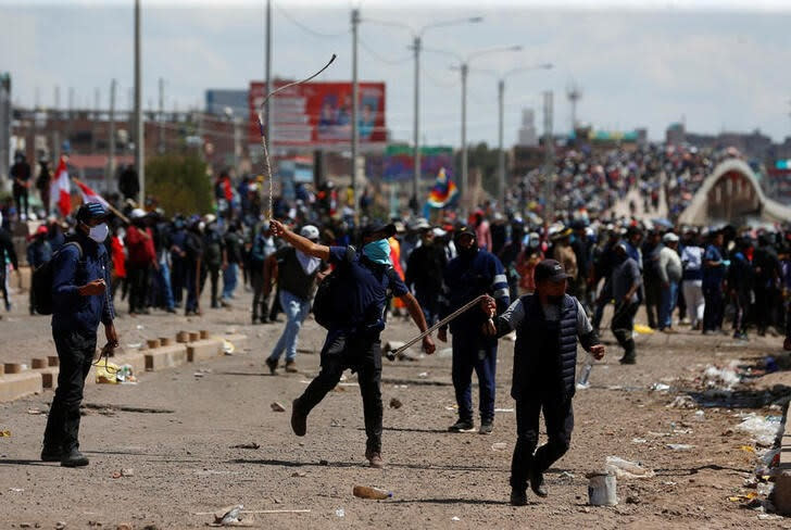 Manifestantes chocan con las fuerzas de seguridad durante una protesta que exige elecciones anticipadas y la liberación del encarcelado expresidente Pedro Castillo, cerca del aeropuerto de Juliaca, en Juliaca, Perú