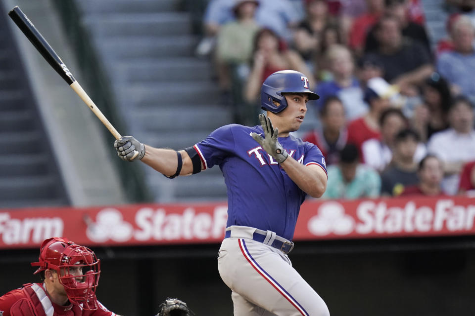 Texas Rangers' Nathaniel Lowe, right, follows through after hitting an RBI-single during the third inning of a baseball game against the Los Angeles Angels, Saturday, July 30, 2022, in Anaheim, Calif. (AP Photo/Jae C. Hong)