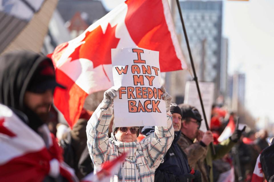 A demonstrator holds a sign during a protest against mandates related to COVID-19 vaccines and restrictions in downtown Toronto, Ontario, Canada, on Feb. 5, 2022. Protesters again poured into Toronto and Ottawa to join a convoy of truckers whose occupation of Ottawa to denounce COVID vaccine mandates is now in its second week.