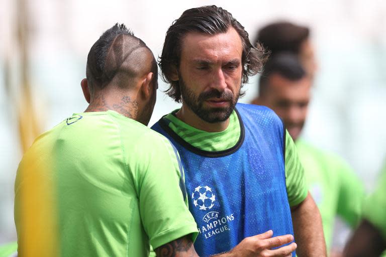 Juventus' Andrea Pirlo (C) talks to teammate Arturo Pardo Vidal during a training session at the Juventus Stadium in Turin, on June 1, 2015, five days ahead of their UEFA Champions League final against Barcelona