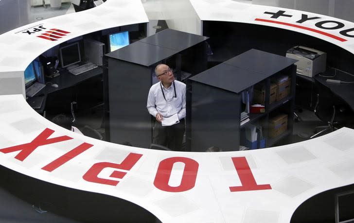 An employee of the Tokyo Stock Exchange (TSE) looks at a stock quotation board as he works at the bourse at TSE in Tokyo March 13, 2015. REUTERS/Yuya Shino