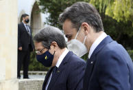 This image provided by Cyprus' press and information office shows Cyprus President Nicos Anastasiades, left, walks with Greece's Prime minister Kyriakos Mitsotakis prior to their meeting, at the presidential palace in capital Nicosia, Cyprus, Monday, Feb. 8, 2021. Mitsotakis is in Cyprus on a one day official visit. (Stavros Ioannides, PIO via AP)