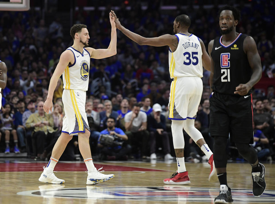 Golden State Warriors guard Klay Thompson, left, and forward Kevin Durant, center, congratulate each other as Los Angeles Clippers guard Patrick Beverley walks by during the second half in Game 4 of a first-round NBA basketball playoff series Sunday, April 21, 2019, in Los Angeles. The Warriors won 113-105. (AP Photo/Mark J. Terrill)