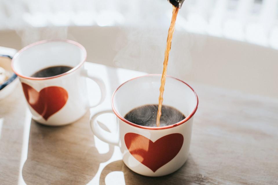 pouring coffee into white mug with heart