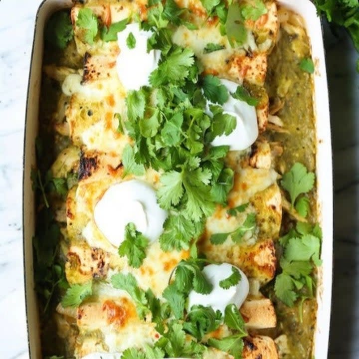 green chicken enchiladas topped with sour cream and cilantro