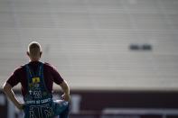 Texas A&M University Yell Leader Jacob Huffman takes a knee while looking over the empty stands at Kyle Field in College Station, Texas during the first Midnight Yell Practice this season early Saturday, Sept. 26, 2020. Due to Coronavirus restrictions, the Texas A&M Band were the only crowd allowed in the normally packed stands for the traditional game day event in College Station, Texas. (Sam Craft/Pool Photo via AP)