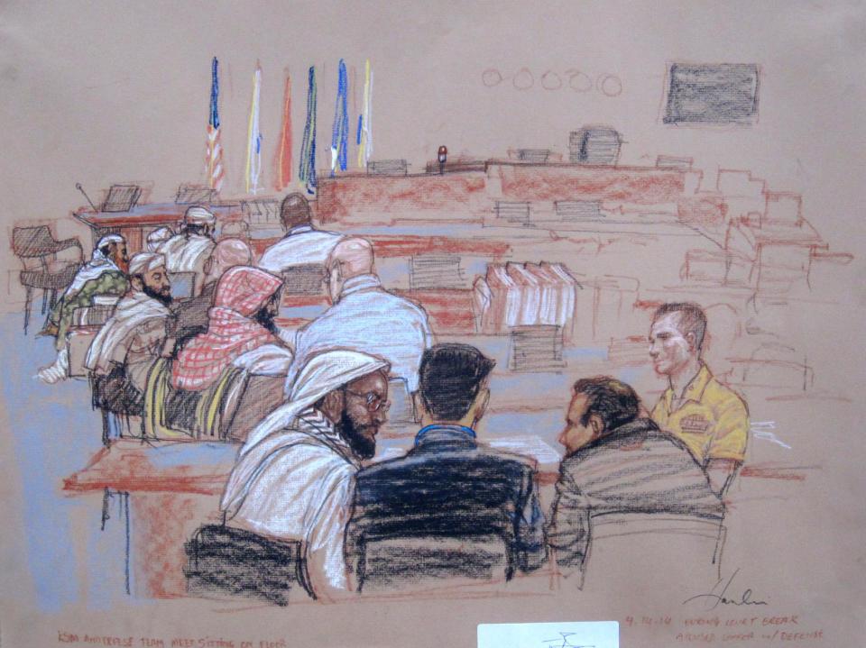 In this pool photo of a Pentagon-approved sketch by court artist Janet Hamlin, defendants speak with their defense lawyers during a break in pretrial hearings at the Guantanamo Bay U.S. Naval Base in Cuba, Monday, April 14, 2014. From right to left are Mustafa al Hawsawi, Ali Abdul Aziz Ali, Ramzi bin al Shibh, and Khalid Sheikh Mohammad sitting on the floor with Walid bin Attash sitting on a chair. A lawyer for one of five defendants in the Sept. 11 war crimes tribunal said Monday that FBI agents questioned a member of his defense team, apparently in an investigation related to the handling of evidence, a revelation that brought an abrupt halt to proceedings. (AP Photo/Janet Hamlin, Pool)