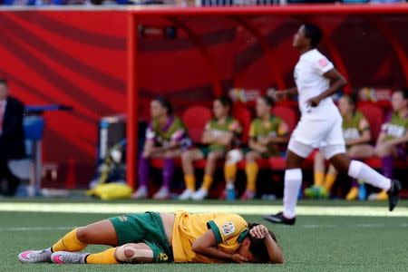 Jun 12, 2015; Winnipeg, Manitoba, CAN; Australia forward Samantha Kerr (20) lay on the ground injured after being elbowed in the face during the second half against as Nigeria defender Ugo Njoku (back) runs past in a Group D soccer match in the 2015 FIFA women's World Cup at Winnipeg Stadium. Mandatory Credit: Bruce Fedyck-USA TODAY Sports