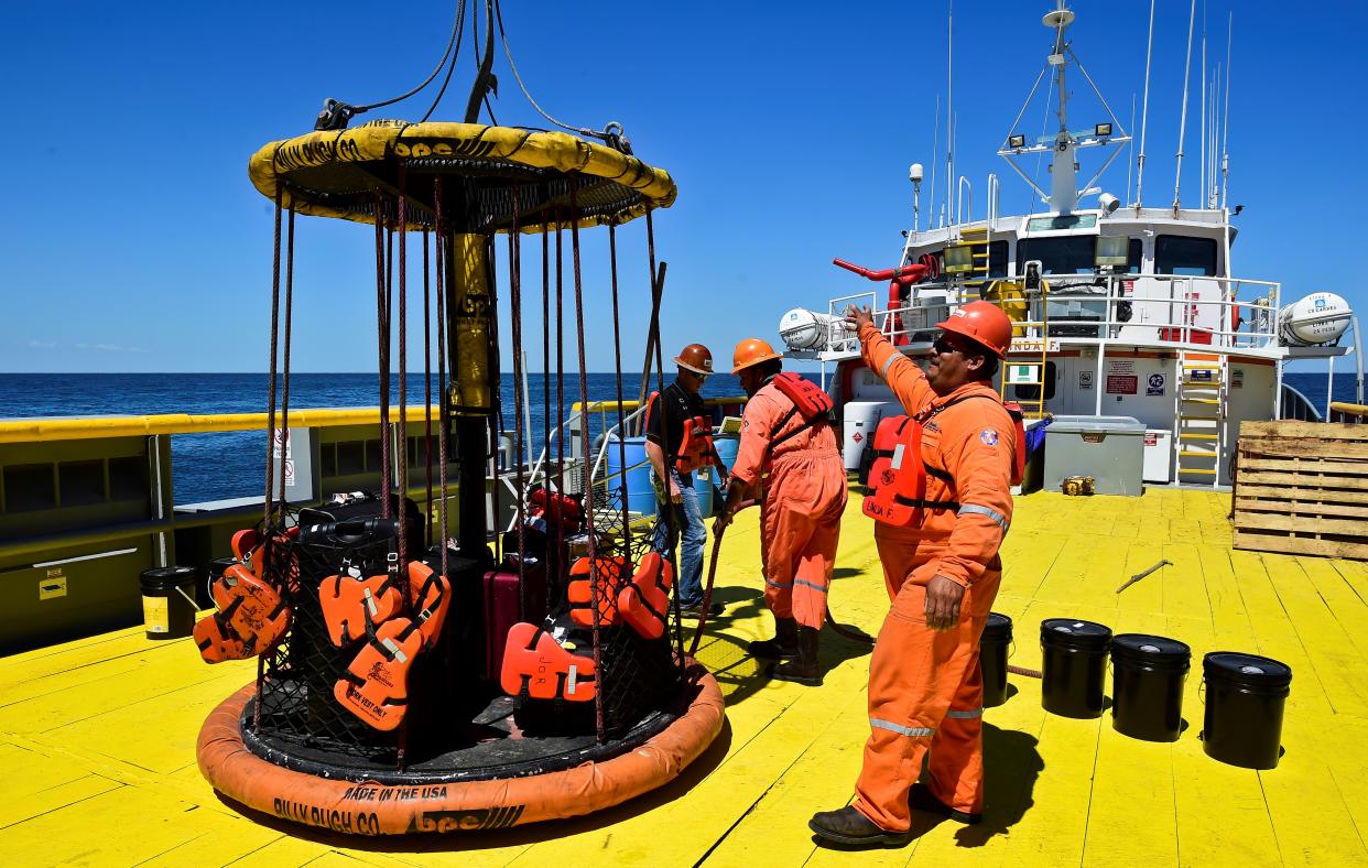 Sailors and workers load members luggage onto the L/B MYRTLE Offshore Support Vessel -a scientific plataform working in the Gulf of Mexico- in front of the Yucatan State, in Mexico, on May 7, 2016.  A scientific mission led by IODP (International Ocean Discovery Program) studies the Chicxulub impact crater on the Gulf of Mexico, created after an asteroid crashed 66 million years ago. The research aims to find evidence of the origin of the universe and the evolution of life on Earth. / AFP / RONALDO SCHEMIDT        (Photo credit should read RONALDO SCHEMIDT/AFP/Getty Images)