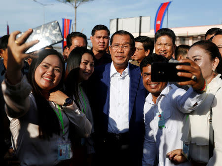 Supporters take pictures with Cambodia's Prime Minister Hun Sen (C) as he attends an inauguration of a new boat terminal in Phnom Penh, Cambodia August 1, 2018. REUTERS/Samrang Pring