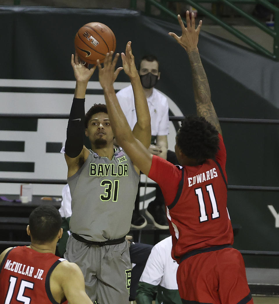Baylor guard MaCio Teague (31) shoots a three-point basket past Texas Tech guard Kyler Edwards (11) in the second half of an NCAA college basketball game Sunday, March 7, 2021, in Waco, Texas. (AP Photo/Jerry Larson)