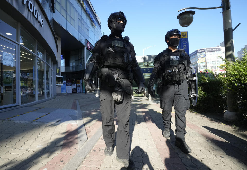 Police officers patrol around Ori subway station following Thursday's attack in Seongnam, South Korea, Friday, Aug. 4, 2023. South Korean police detained a man suspected of stabbing a high school teacher with a knife Friday in the city of Daejeon. The stabbing follows a separate, apparently random attack on Thursday in which 14 people were wounded near a busy subway station in Seongnam. (AP Photo/Ahn Young-joon)