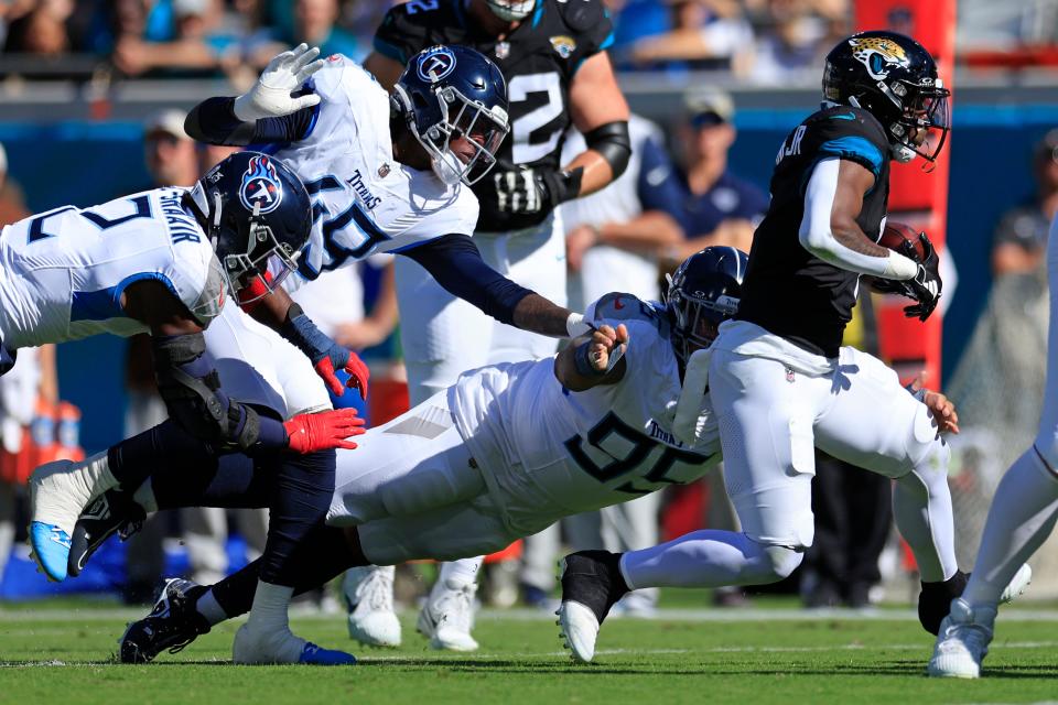 Jacksonville Jaguars running back Travis Etienne Jr. (1) outpaces Tennessee Titans defensive tackle Kyle Peko (95), linebacker Arden Key (49) and linebacker Azeez Al-Shaair (2) during the first quarter an NFL football matchup at EverBank Stadium in Jacksonville, Fla.