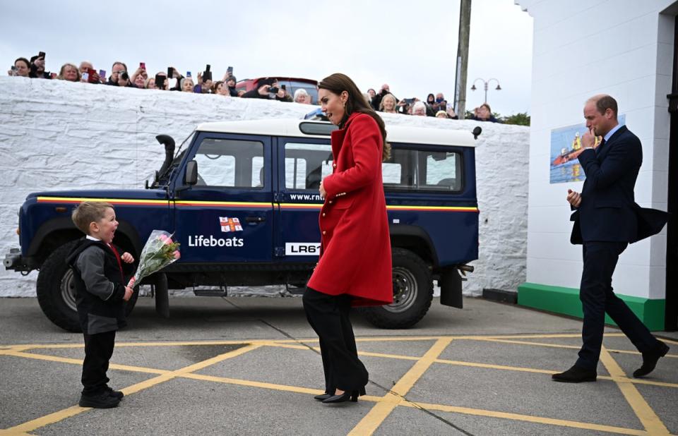 William, Prince of Wales looks on as his wife Catherine is presented with a posy of flowers by four-year-old Theo Crompton (Getty Images)