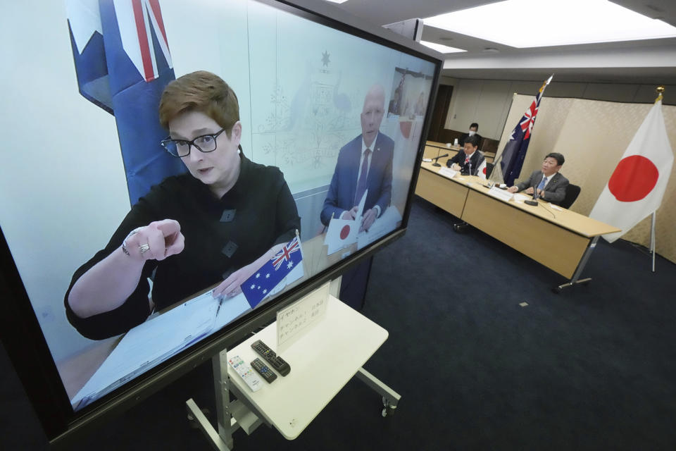 Japanese Foreign Minister Toshimitsu Motegi, right, and Defense Minister Nobuo Kishi, second right, attend a video conference with Australian Foreign Minister Marise Payne, left on screen, and Australian Defense Minister Peter Dutton, right on screen, at Foreign Ministry in Tokyo during their two-plus-two ministerial meeting Wednesday, June 9, 2021, in Tokyo. (AP Photo/Eugene Hoshiko, Pool)