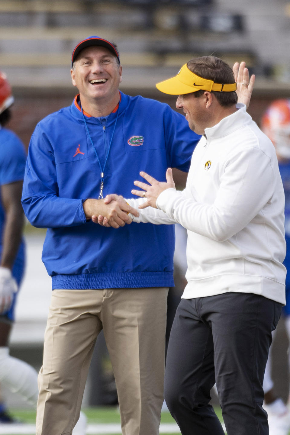 Florida coach Dan Mullen, left, greets Missouri coach Eliah Drinkwitz before an NCAA college football game Saturday, Nov. 20, 2021, in Columbia, Mo. (AP Photo/L.G. Patterson)