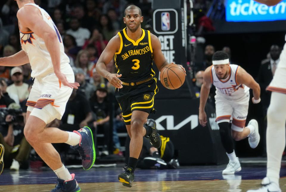 Golden State Warriors guard Chris Paul (3) brings the ball up court against the Phoenix Suns at Footprint Center in Phoenix on Nov. 22, 2023.