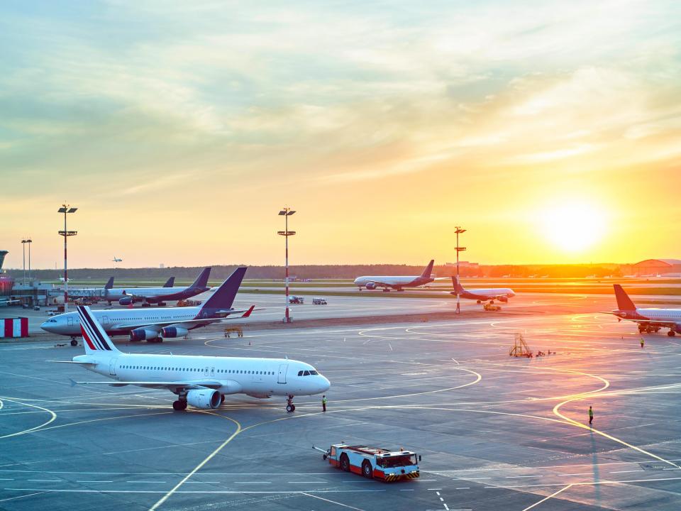 View of planes on airport runway at sunset