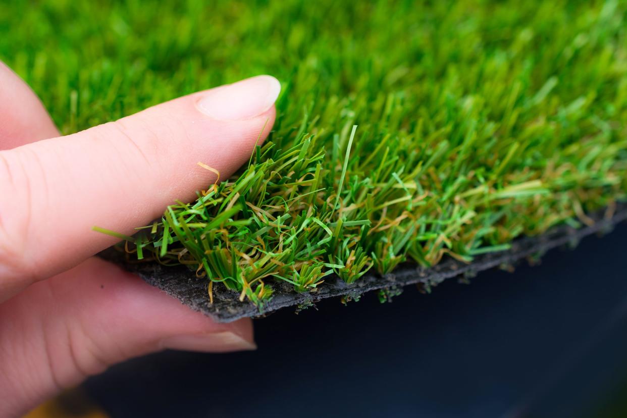 woman holding artificial grass in her hand