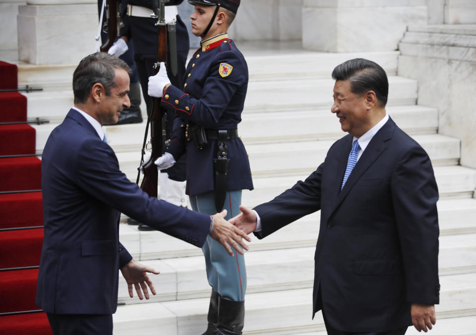 Greece's Prime Minister Kyriakos Mitsotakis, left, reaches out to shake hands with China's President Xi Jinping, right, prior to their meeting at Maximos Mansion in Athens, Monday, Nov. 11, 2019. Xi Jinping is in Greece on a two-day official visit. (AP Photos/Thanassis Stavrakis)