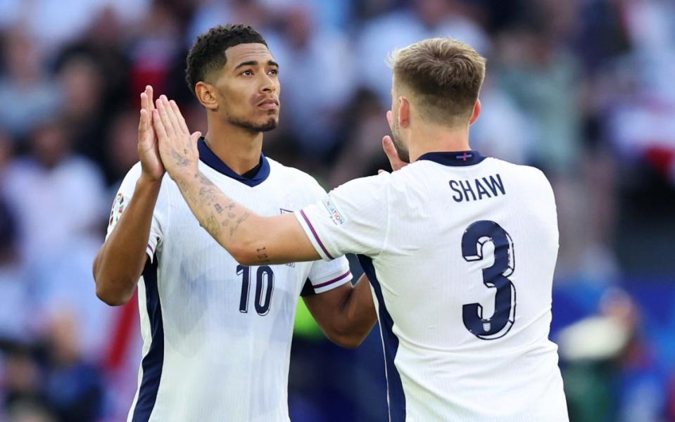 Jude Bellingham high fives with Luke Shaw after scoring his penalty