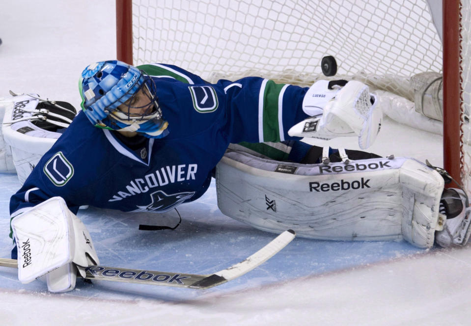 FILE - In this Nov. 17, 2013, file photo, a shot by Dallas Stars Erik Cole sails past Vancouver Canucks goalie Roberto Luongo during an NHL hockey game in Vancouver, British Columbia, Sunday, Nov. 17, 2013. The Canucks have traded Luongo to the Florida Panthers. (AP Photo/The Canadian Press, Jonathan Hayward)