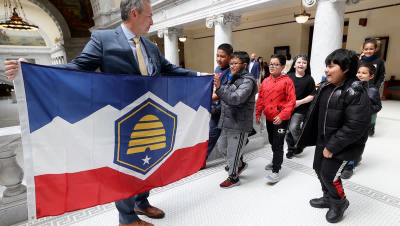 Sen. Daniel McCay, R-Riverton, sponsor of SB31, State Flag Amendments, shows fifth grade students from Academy Park Elementary School the new Utah state flag at the Capitol in Salt Lake City on Thursday, March 2, 2023.