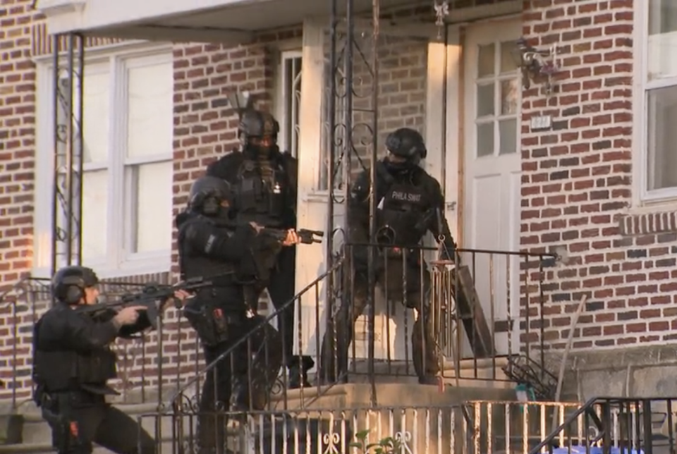 A SWAT team assisting homicide investigators prepares to enter a home in Philadelphia. / Credit: CBS News