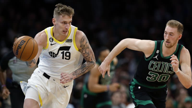 Utah Jazz’s Luka Samanic (19) drives past Boston Celtics’ Sam Hauser (30) during the first half of an NBA basketball game Friday, March 31, 2023, in Boston. 