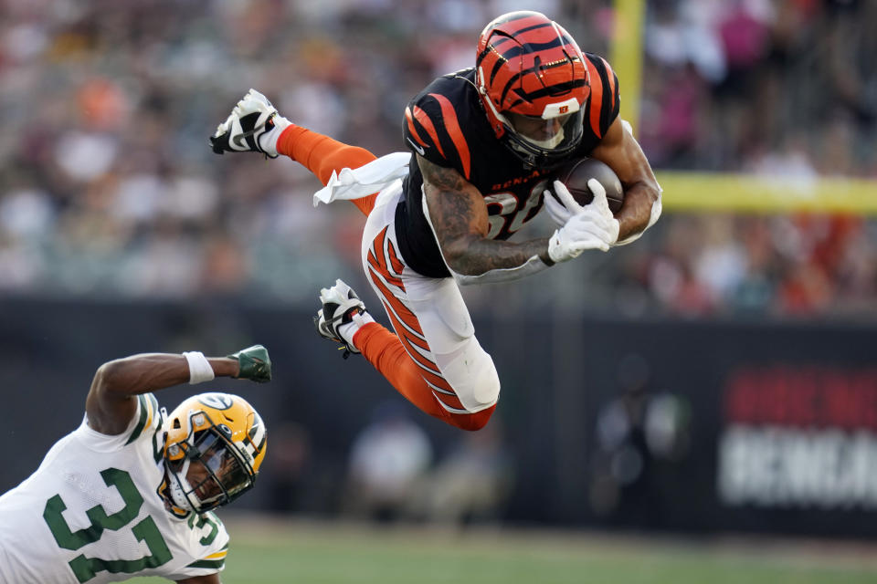 Cincinnati Bengals running back Chase Brown leaps over Green Bay Packers cornerback Carrington Valentine (37) during the first half of a preseason NFL football game Friday, Aug. 11, 2023, in Cincinnati. (AP Photo/Michael Conroy)