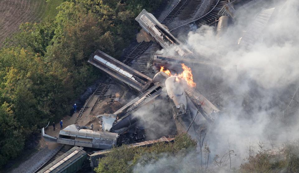 Officials walk alongside a derailed freight train on July 11, 2012 in Columbus. Part of the freight train carrying ethanol derailed and caught fire. Railroads and owners of the cars that ride on their tracks are responsible for regularly inspecting track, signals and rolling stock, while the federal government, which regulates railroads, inspects them only occasionally.