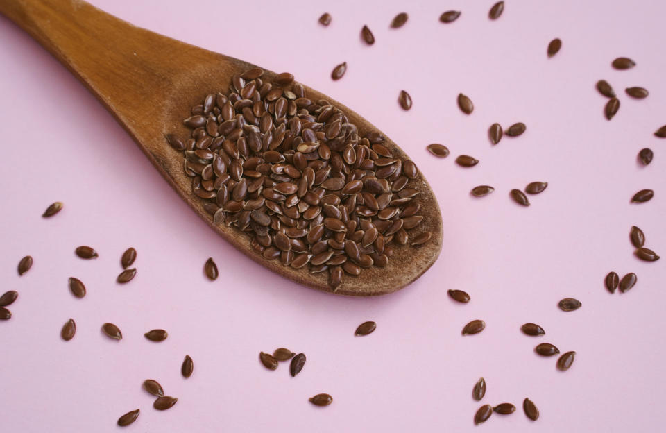 Flaxseeds on purple background.