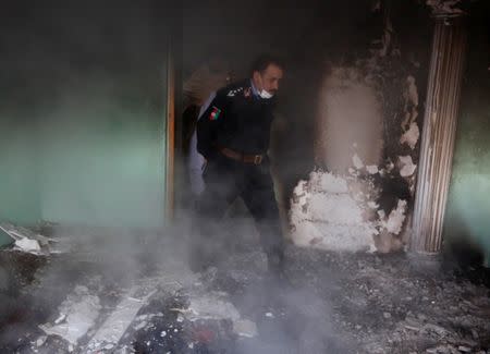 An Afghan police officer inspects the house of an Afghan member of parliament which was attacked by Taliban last night in Kabul, Afghanistan December 22, 2016. REUTERS/Omar Sobhani