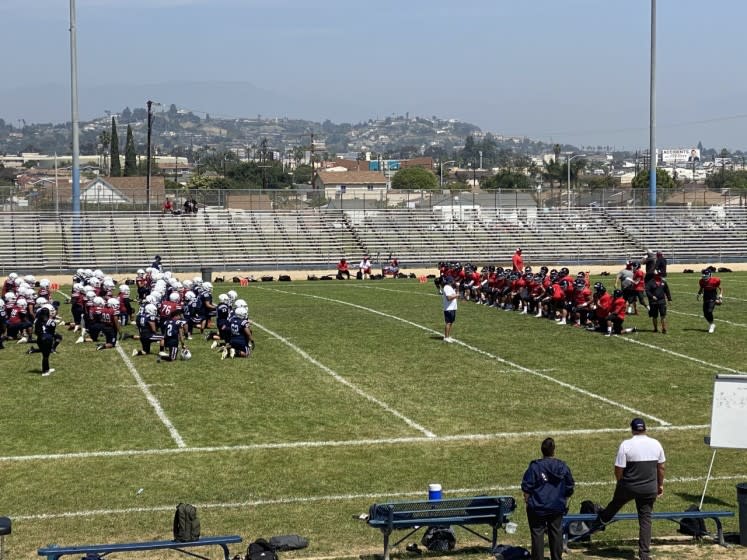 Players for Garfield, left, and Banning gather before a scrimmage April 3, 2021.
