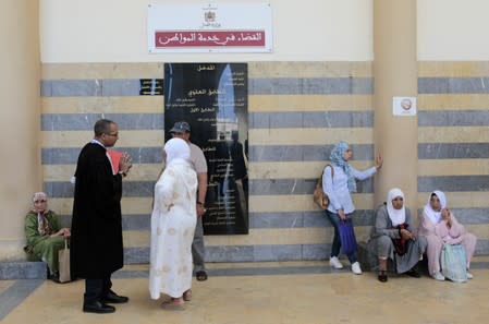 People wait outside a court before the arrival of men accused in the killing of a Danish and Norwegian hikers, in Sale