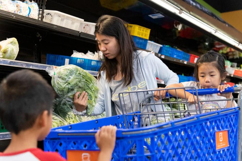 Stacy Lin, 30, of Meridian, shops for vegetables with her son, Austin, and daughter, Mia, at the Idaho Capital Asian Market on July 31. The market was one of the first businesses to open in the Idaho Asian Plaza at North Cole and Ustick Roads after it was purchased in 2018 by a Utah developer with plans to turn the area into a Boise Chinatown. Dillon Luo, the owner and manager, said the store is in talks to knock down the wall of a neighboring unit and expand, adding more shelves and a food court selling Asian goods.