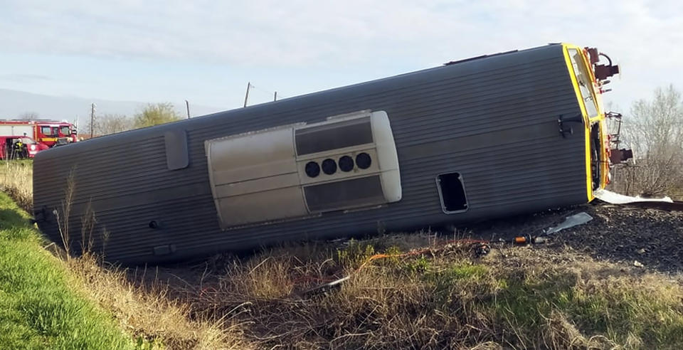 A derailed train carriage lies on its side after a fatal collision with a van in Mindszent, Hungary on Tuesday, April 5, 2022. Police say a train has struck a vehicle in southern Hungary and derailed, leaving several people dead and others injured. The accident occurred just before 7 a.m. in the town of Mindszent. (Csongrad-Csanad County Police via AP)