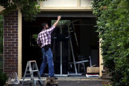 An Australian Federal Police officer closes the door of the garage after searching the home of probable creator of cryptocurrency bitcoin Craig Steven Wright in Sydney's north shore December 9, 2015. REUTERS/David Gray