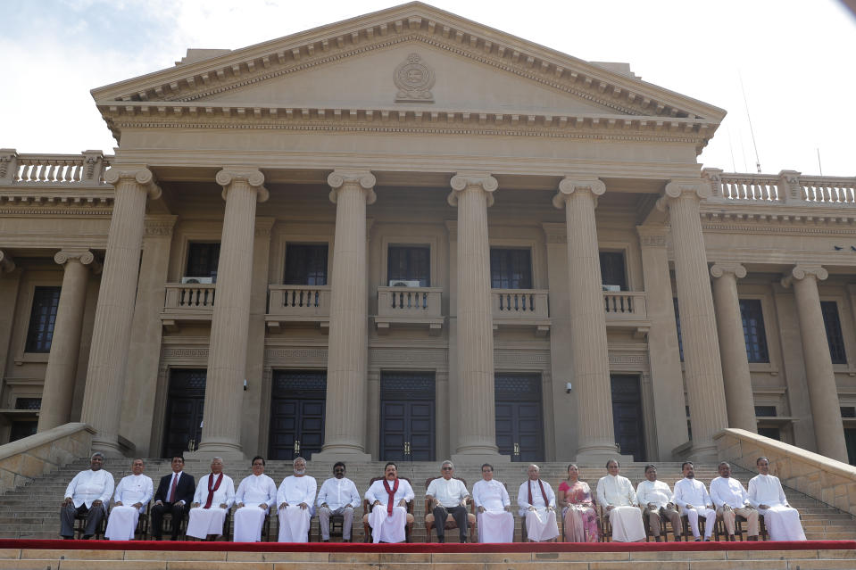 Sri Lankan president Gotabaya Rajapaksa, seated center, sits for photographs with his new cabinet members in Colombo, Sri Lanka, Friday, Nov. 22, 2019. Rajapaksa, who was elected last week, said he would call a parliamentary election as early as allowed. The parliamentary term ends next August, and the constitution allows the president to dissolve Parliament in March and go for an election. (AP Photo/Eranga Jayawardena)