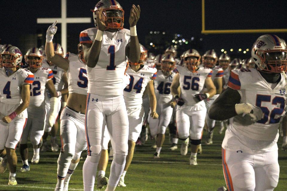 Quarterback D.J. Moore (1) and Bolles teammates rush onto the field before last October's game at Bishop Kenny.
