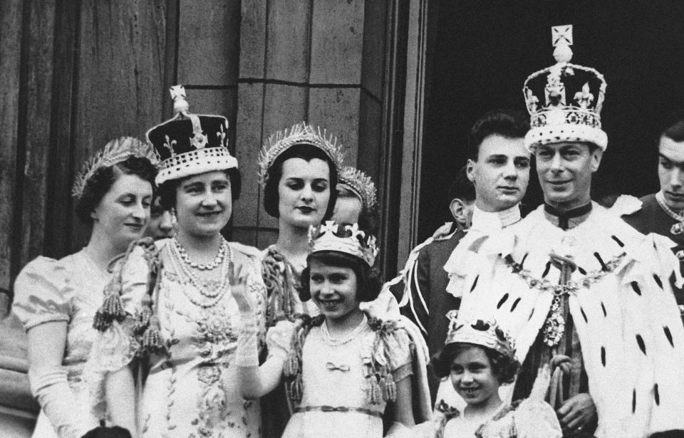 FILE - Princess Elizabeth, centre, age 11, appears on the balcony of Buckingham Palace after the coronation of her father, King George VI, right, in London, May 12, 1937. Queen Elizabeth II, Britain’s longest-reigning monarch and a rock of stability across much of a turbulent century, has died. She was 96. Buckingham Palace made the announcement in a statement on Thursday Sept. 8, 2022. (AP Photo, File)