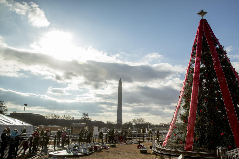 Visitors to the National Christmas Tree on the Ellipse look at holiday decorations as National Park Service employees briefly open the venue before quickly having to close again due to electrical problems, Monday, Dec. 24, 2018, in Washington. Repairs were delayed because of a partial government shutdown. Both sides in the long-running fight over funding President Donald Trump's U.S.-Mexico border wall appear to have moved toward each other, but a shutdown of one-fourth of the federal government entered Christmas without a clear resolution in sight. (AP Photo/Andrew Harnik)
