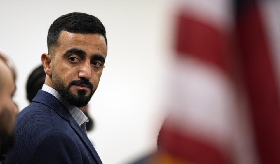 Abdul Wasi Safi listens during a news conference Friday, Jan. 27, 2023, in Houston. Wasi Safi, an intelligence officer for the Afghan National Security Forces who fled Afghanistan following the withdrawal of U.S. forces, was freed this week and reunited with his brother after spending months in immigration detention. (AP Photo/David J. Phillip)