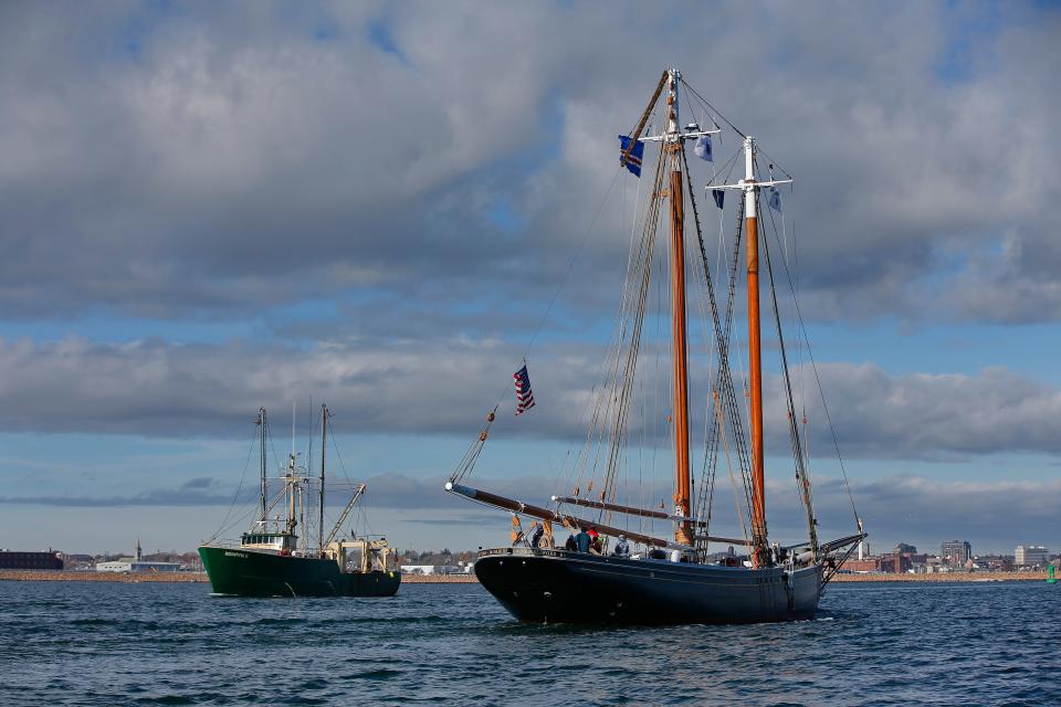 A fishing boat heads out to sea as the historic schooner Ernestina-Morrissey returns to New Bedford after a seven-year restoration performed in Boothbay Harbor, Maine.